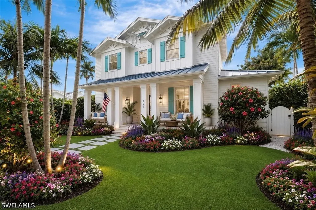 White coastal house with turquoise shutters and palms; SWFLAMLS watermark retained